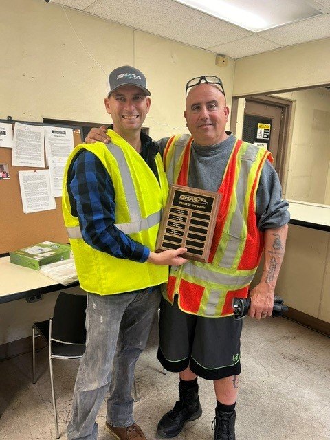 Team members holding a performance award